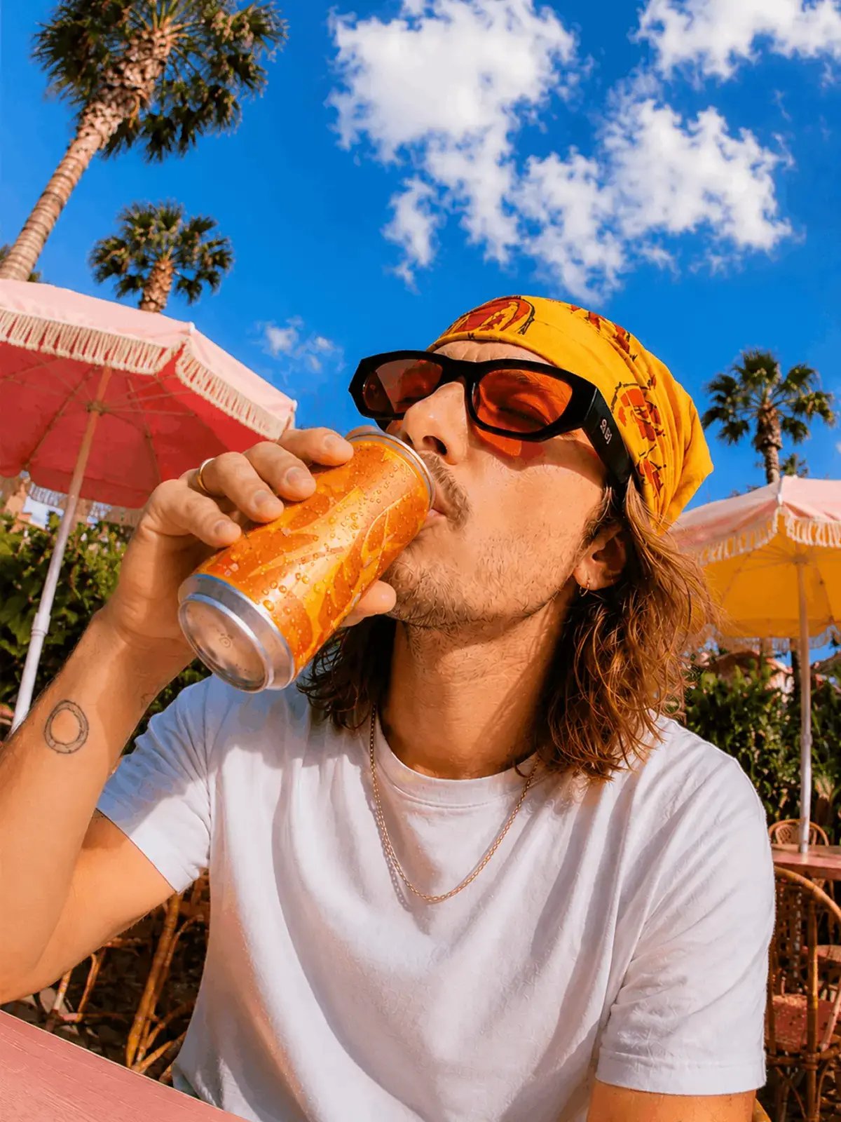 Un jeune homme boit une canette au soleil