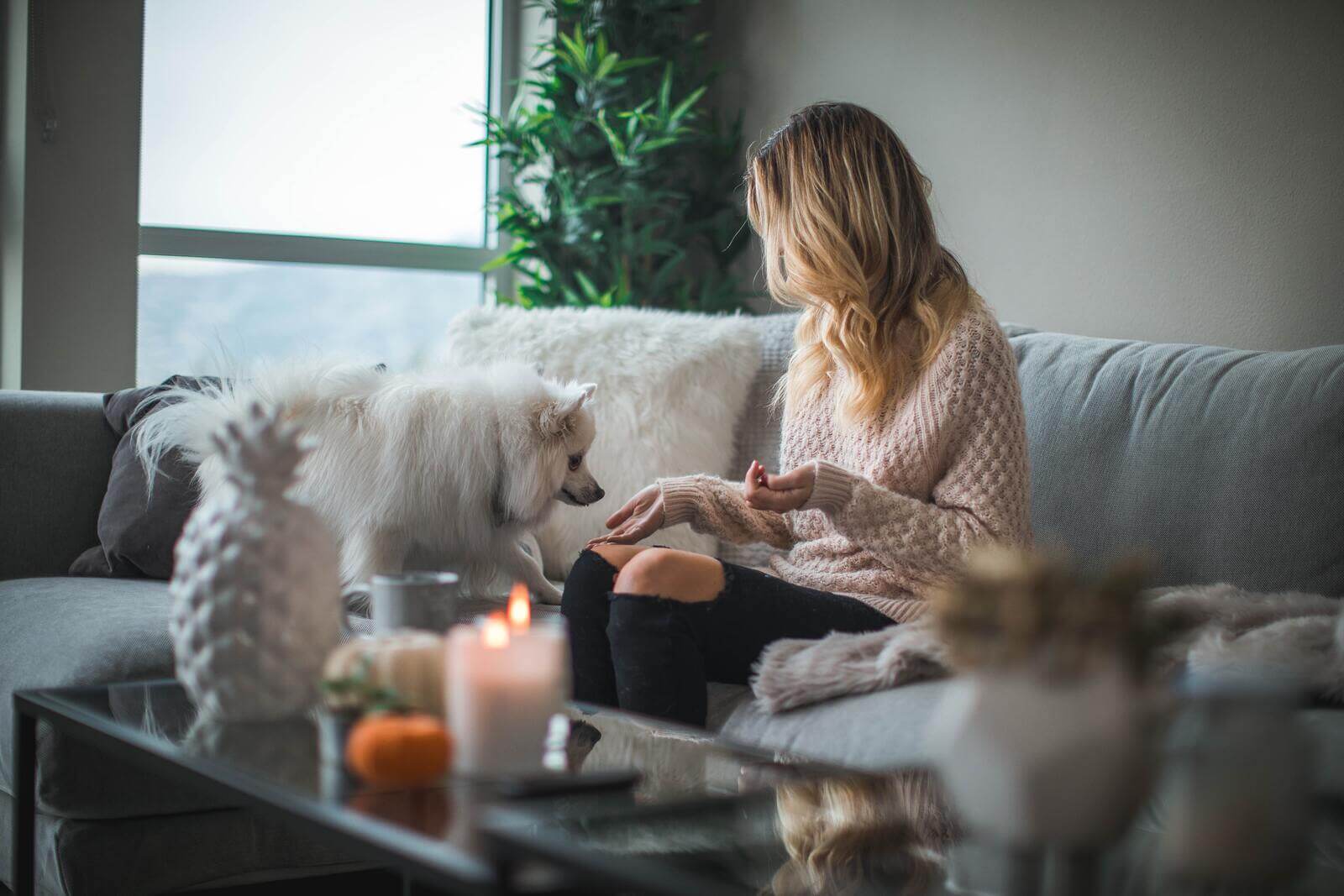 Influenceuse avec son chien et une bougie allumée